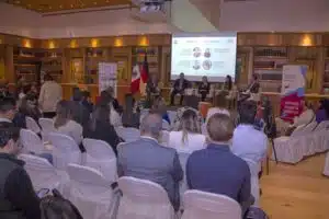 Participants of the HSC Roundtable in Mexico are sitting in the audience and listening to a panel discussion on stage. 